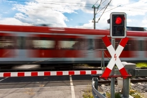 Andreaskreuz mit rotem Blinklicht: Fahrzeuge und Fußgänger müssen warten.