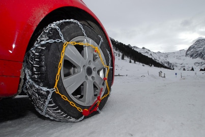 Auf die Winterreifen Schneeketten aufziehen? Pflicht in der Schweiz ist das bei entsprechender Beschilderung.